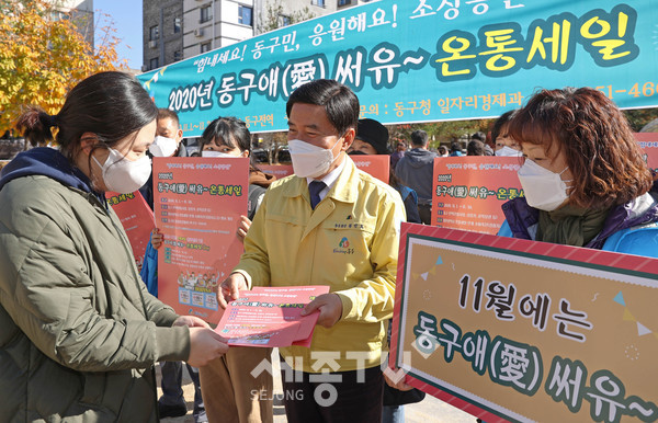 4일 용운동 용수골어린이공원에서 진행된 ‘동구애(愛) 써유~ 온통세일’ 성공 기원 및 홍보 캠페인에서 황인호 동구청장이 한 시민에게 홍보안내문을 전달하며 참여를 당부하는 모습.(사진제공=동구청)