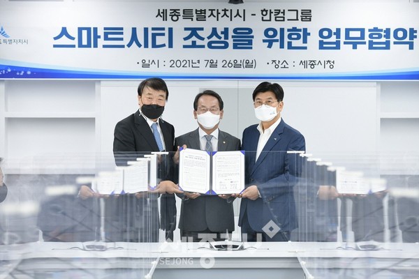 (왼쪽부터)김상철 한글과컴퓨터그룹 회장, 강준현 국회의원, 이춘희 세종시장이 ‘세종형 스마트시티 조성을 위한 업무협약’을 체결하고 있다.(사진=세종시 제공)