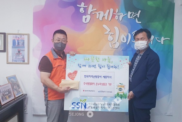 한국지역난방공사 세종지사 임재구 부장(사진 오른쪽)이 김부유 협의회장에게 온누리 상품권을 전달하고 있다.(사진=세종시사회복지협의회 제공)