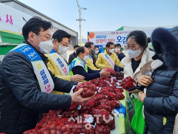 양승조 충남도지사(왼쪽 뒤)와 이종욱 충남세종농협본부장(왼쪽 앞)이 설명절 내포직거래 장터를 찾은 도민들에게 공주밤을 나누어 주고 있다.