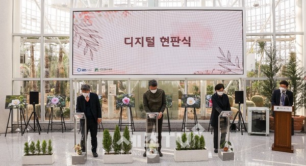 한국수목원정원관리원(류광수 이사장), SBS A&T(이동협 대표), 국립세종수목원(이유미 원장)은 포디움 위에 손을 올려 디지털 현판식을 진행하고 있다.