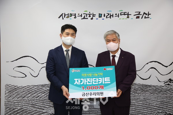 금산우리의원 정현철 원장(왼쪽)이 물품을 전달하고 문정우 금산군수와 기념사진을 찍고 있다.