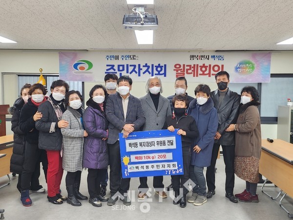 9일 유춘하 천안시 백석동 주민자치회장이 백석동에 백미를 기탁하고 기념촬영을 하고 있다.