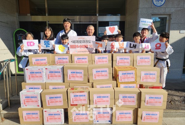 3일 박상현 세계로태권도 관장이 정근혁 신안동장과 함께 라면·수세미 기부 전달식 이후 기념촬영을 하고 있다.