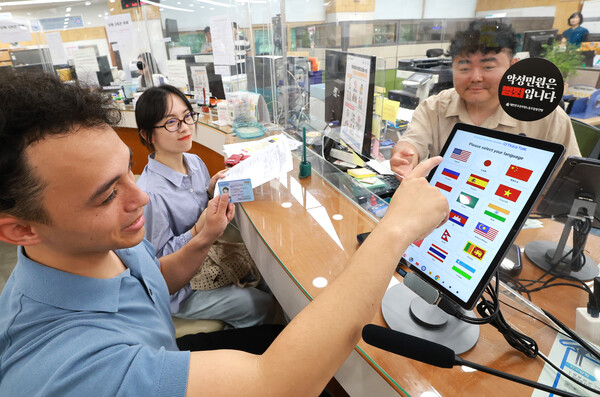 유성구청을 방문한 외국인이 AI 기반 통번역기를 활용해 체류지 변경 신고를 하고 있다.