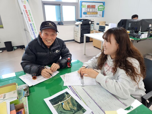 청주시 흥덕구 건축과 직원이 민원인에게 건축물 표시변경 도면 대행 작성 서비스를 안내하고 있다. (사진 청주시 제공)